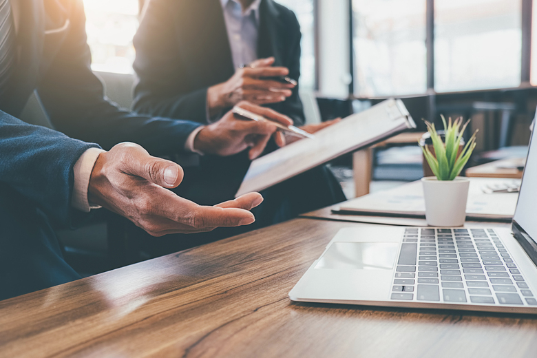 Pessoas trabalhando em frente a um laptop